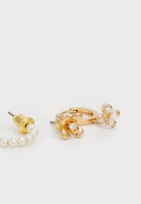 Orecchini a forma di fiore in tono oro con accenti di perla. Uno ha gemme trasparenti, l'altro presenta una pietra centrale simile a un diamante e petali arrotondati.
