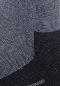 Hallide ja musta sokki, millel on ridustatud tekstuur, sile kudumise osa ja eristuv värvi blokeering, millel on tugevdatud varbaosa.