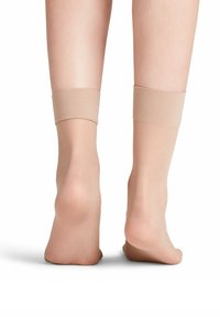 Nude Knöchelsocken mit einer glatten Textur und einem weichen Bund oben; designed, um bequem um die Knöchel zu passen, ohne zu verrutschen.