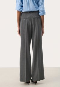 Gray pinstriped wide-leg trousers with two back pockets and tailored fit, paired with a light blue button-up shirt, visible at the sleeves.