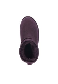 Stivaletto alla caviglia in suede viola con un morbido interno foderato in pelliccia e un accento cucito intorno alla parte superiore. Suola piatta, forma arrotondata, e linguetta sul retro.
