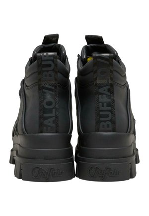 Černé robustní platformové tenisky s tlustými podrážkami, polstrovanými límci a označením „Buffalo“ na patních páscích a podrážkách, zobrazené zezadu.