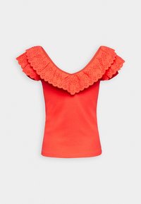 Korallfärgad topp med V-ringning och stora, scalloperade ögonlidsflikarna. Mjuk textur, figurnära design. Inga synliga knäppningar eller mönster på kroppen.