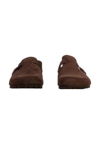 Chaussures à enfiler en daim marron avec des ouvertures larges, une texture douce et une petite semelle antidérapante ; dotées d'une boucle décorative de chaque côté.