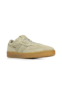 Zapatillas de ante en tono marrón claro con suela de goma, con un diseño de cordones, marca en relieve y rayas laterales sutiles.