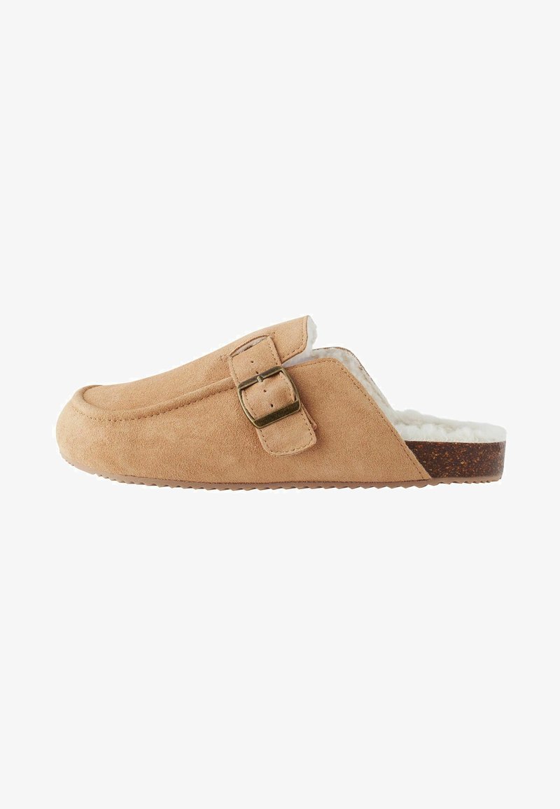 Suedeslipper i beige med mjukt vitt foder, med en sidbuckle och en strukturerad korkliknande sula för bra grepp.