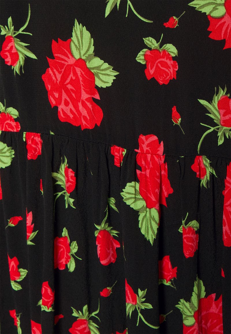 Zwarte jurk met een bloemenpatroon van rode rozen en groene bladeren, met een geplooide textuur rond de taille voor een vloeiende silhouet.