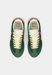 Πράσινα αθλητικά παπούτσια από δίχτυ και σουέντ με ροζ λεπτομέρειες, εκρού κορδόνια και ταμπά λαστιχένια σόλα. Διαθέτουν λογότυπο στη γλώσσα και στο πλάι.
