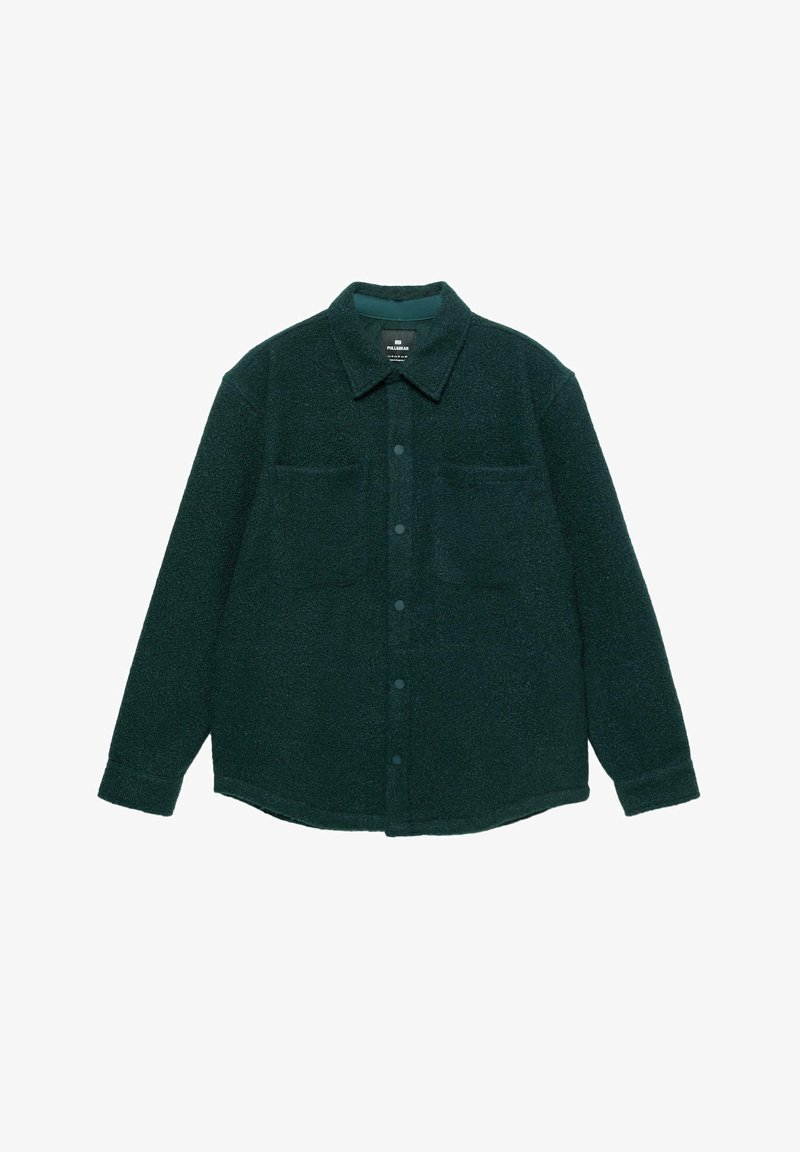 Giacca camicia in pile verde scuro con chiusura a bottoni, colletto a punta, due tasche sul petto e maniche lunghe. Texture morbida e design casual.