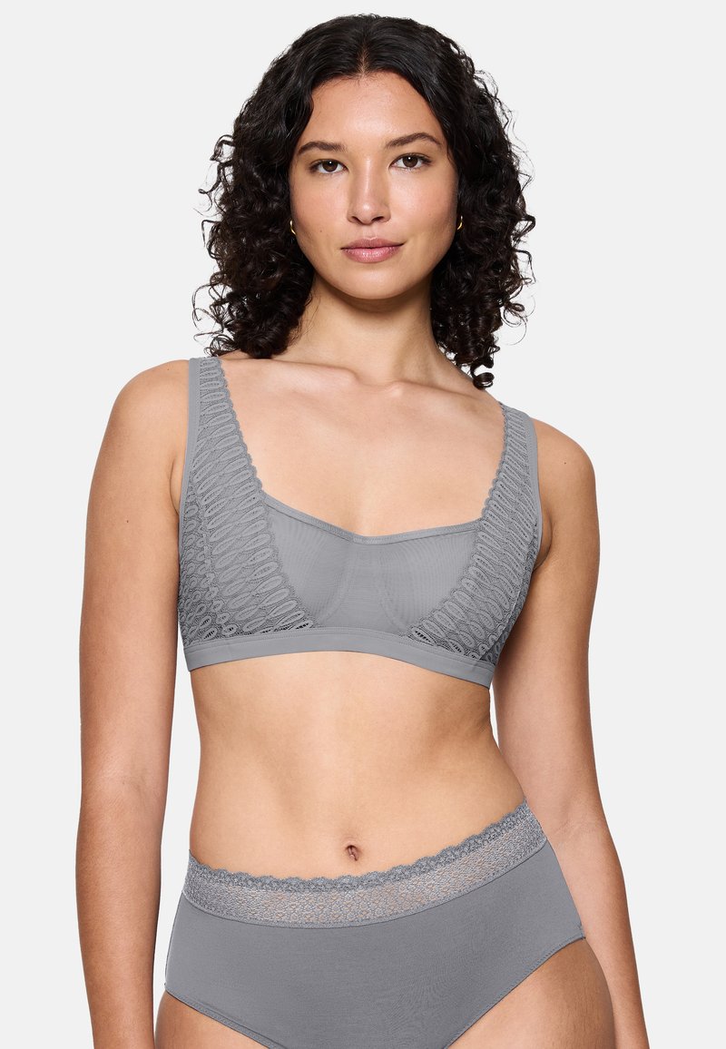 Bralette grigia caratterizzata da un tessuto testurizzato e lavorato, con spalline larghe e design senza cuciture. Accompagnato da un coordinato di mutande a vita alta.