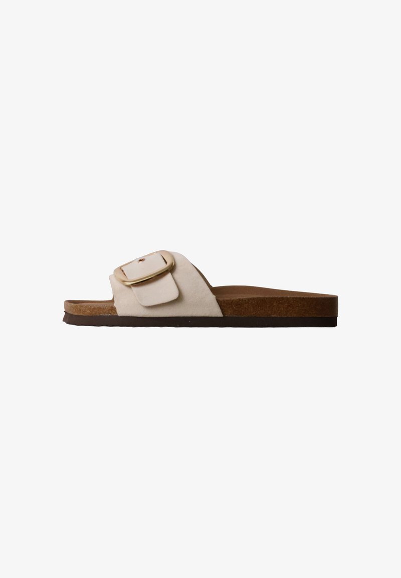 Sandale mule beige en daim avec une bride large, une grande boucle dorée, une semelle intérieure en liège et une fine semelle noire, vue de côté.
