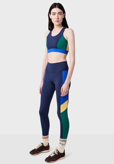 Sport-bh och leggings-set med blå, gröna och gula paneler. Slät, stretchig tyg med en figurnära design; högmidjade leggings.
