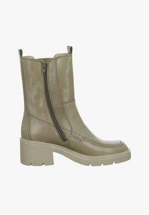 Green leather ankle boot with a rounded toe, dual side zippers, and a chunky, textured light beige sole. Features stitched accents.