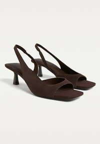 Bruna mocka slingbackklackar med öppen tå, fyrkantiga sulor och en medelhög blockklack för stöd. Enkelt design med rena linjer.