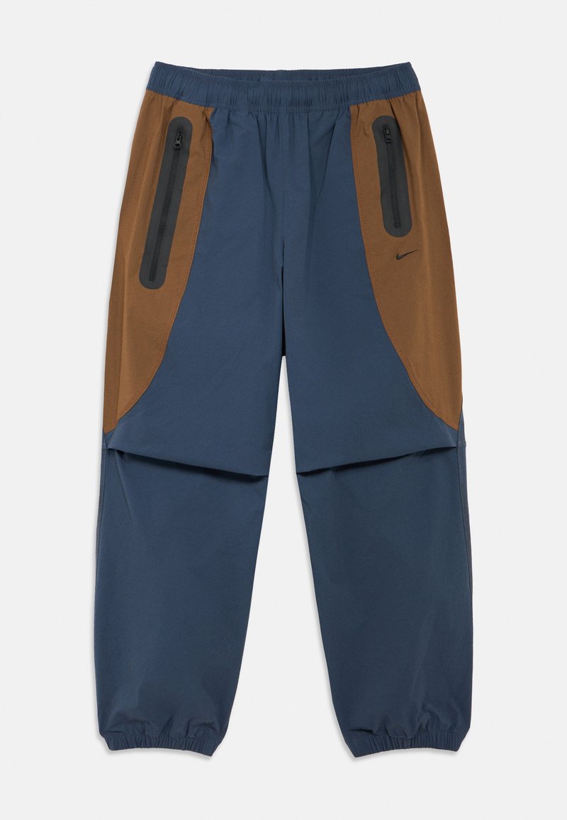 Σκούρο μπλε παντελόνι με καφέ λεπτομέρειες, διαθέτει φερμουάρ σε τσέπες, λάστιχο στη μέση και λάστιχο στα μπατζάκια στον αστράγαλο. Ελαφρύ υλικό.