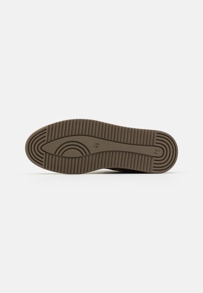 Semelle de sneaker en caoutchouc marron avec des motifs de rainures horizontales et circulaires. Présente un bout arrondi et des bords lisses, design durable.