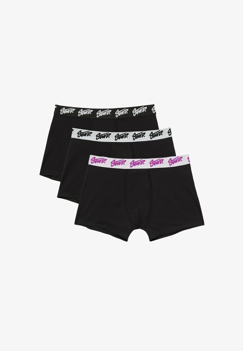Trois boxers noirs avec ceintures élastiques de marque en noir, blanc et blanc avec texte rose, empilés sur un fond blanc.