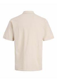 Μπεζ πόλο μπλούζα με κοντά μανίκια, εμφανιζόμενη από πίσω, με κλασικό γιακά και απλό, λείο ύφασμα.