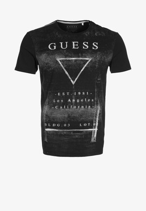 Zwart Guess T-shirt met korte mouwen, witte verweerde driehoek en tekst "GUESS," "EST. 1981," "Los Angeles, Californië," en "BLDG. 03 LOT. 0".