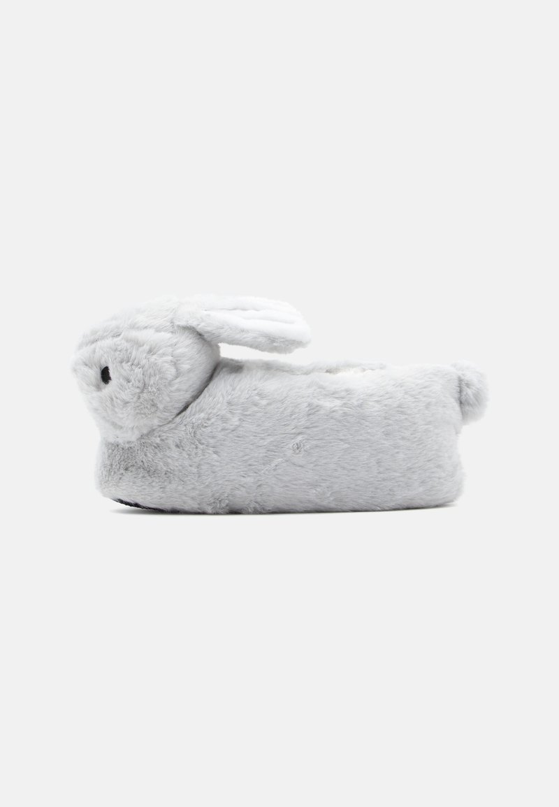 Chausson gris doux en forme de lapin avec des oreilles tombantes, une petite queue et des détails noirs sur le nez.