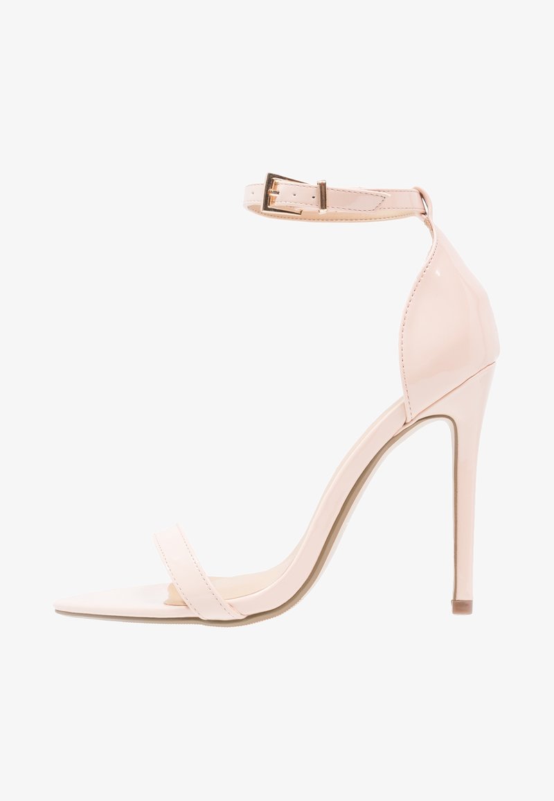 Sandale à talon haut en cuir verni couleur nude, avec une bride à la cheville, un bout pointu et une seule bride à l'avant. Présente une texture élégante et lisse.