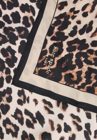 Μαντίλι με σχέδιο λεοπάρ, σε αποχρώσεις μπεζ, μαύρου και καφέ, με μαύρη μπορντούρα και χρυσό λογότυπο "kate spade" στη γωνία.