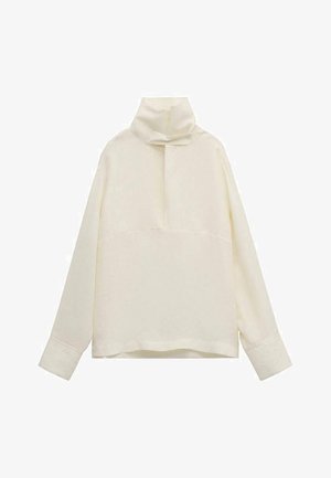 Haut à manches longues de couleur crème avec col haut et détail de col boutonné, coupe ample et larges poignets.