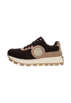 Low-top sneaker med sort og beige ruskind, kraftig lys brun sål, rund beige logo-patch på siden og sorte snørebånd.