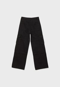 Pantalon cargo noir à jambes larges avec deux poches arrière, deux poches latérales à rabat et coutures apparentes sur les jambes.