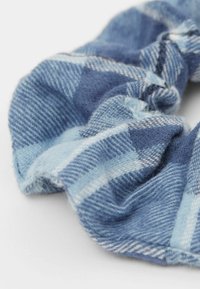 Modrý kostkovaný skřipc s měkké tkaniny, s výraznými světle a tmavě modrými odstíny a tkanou strukturou a shromážděným designem.