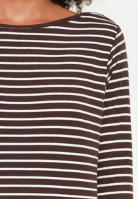 Braun-weiß gestreiftes Langarmoberteil mit weitem Ausschnitt und einer glatten, weichen Textur. Die Streifen sind gleichmäßig verteilt.