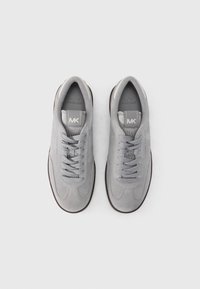 Γκρι σουέντ αθλητικά παπούτσια με στρογγυλερή μύτη, επίπεδα κορδόνια, μαλακό γλωσάκι και υφή σε σόλα. Εμφανίζεται λογότυπο στη γλώσσα και στο πλάι.