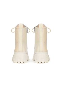 Stivali alla caviglia in pelle beige con suola in gomma bianca testurizzata, dotati di chiusura con zip e linguette sul retro per facilitarne l'indossamento.