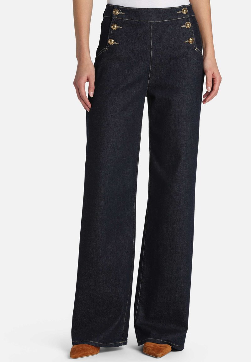 Mørk denim bukser med vide ben, høj talje og gyldne knapdetaljer på venstre side. Kontrastsyninger og blød tekstur.