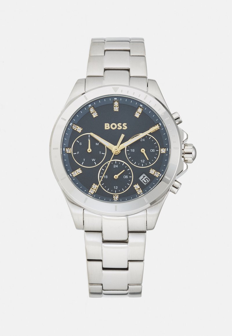 Relógio de aço inoxidável prateado com um mostrador azul-escuro. Acentos em ouro e submostradores de cronógrafo. Marcadores de cristal e exibição da data às 6 horas.