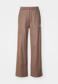 Brown wide-leg sweatpants with an elastic waistband, side pockets, and white stripe accents, featuring a small logo on the left leg.