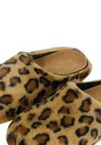 Zoccoli con stampa leopardata caratterizzati da una morbida texture di pelliccia, tacco aperto e una robusta soletta color nocciola, con macchie marrone scuro su una base marrone chiaro.