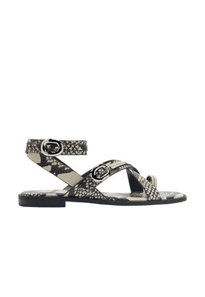 Płaska sandałka z czarno-beżowym wzorem skóry węża, z dwoma srebrnymi klamrami: jedną na palcach, a drugą wokół kostki.