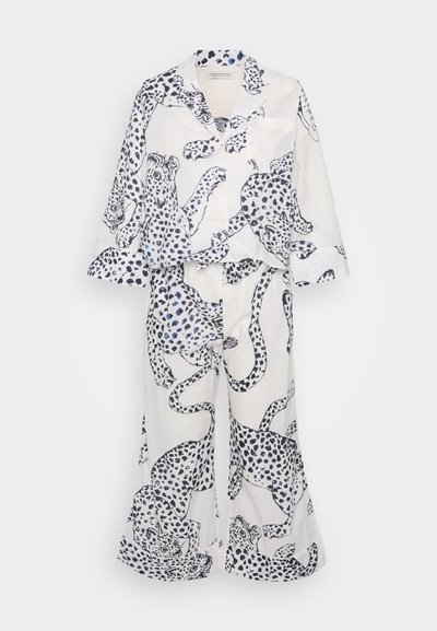 Conjunto de pijama branco com padrão de leopardo em azul e preto. Top solto com lapelas, mangas longas e calças largas.