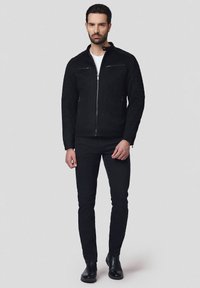 Czarna kurtka z wysokim kołnierzem, z przodu na zamek, oraz dwoma zapinanymi na zamek kieszeniami na piersi. W komplecie z czarnymi slim-fit dżinsami i botkami za kostkę.