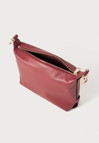 Clutch in pelle bordeaux con cerniera e accessori dorati. Presenta una texture liscia e una forma rettangolare semplice.