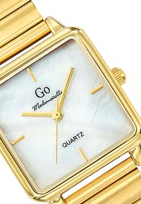 Montre-bracelet en quartz dorée avec un cadran carré, un cadran en nacre, des aiguilles dorées et un bracelet métallique à rayures horizontales.