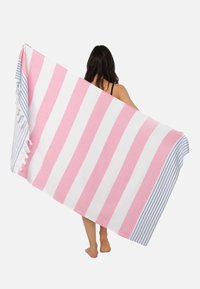 Gran toalla de playa a rayas en rosa y blanco con un acento a rayas en azul y blanco. Presenta borlas a lo largo de un borde. Textura suave.
