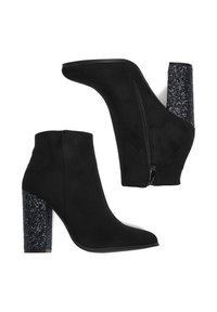 Stivaletti neri in suede con punta affusolata e dettaglio con cerniera. Il tacco è spesso, ricoperto di glitter neri scintillanti.