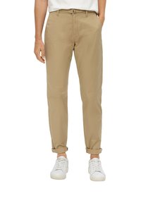 Khaki chino's van lichtgewicht stof, met een relaxed fit, opgerolde mouwen en een voorste riem met een metalen gesp. Gepaard met witte sneakers.