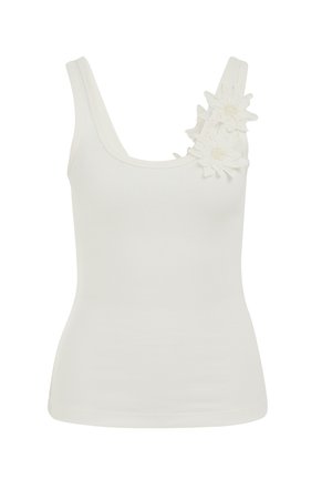 Débardeur blanc côtelé à larges bretelles, avec deux applications florales ornées de perles sur l'épaule gauche.