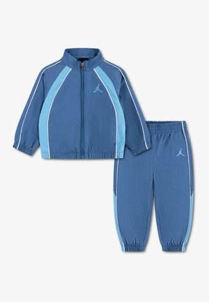 Blauer zweiteiliger Kinder-Trainingsanzug mit hellblauen und weißen Streifen, Jacke mit Reißverschluss und passende Hose mit elastischem Bund.