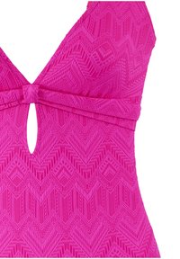 Roze badpak met een geometrisch textuurpatroon, diepe halslijn en een keyhole-detail in het midden van de buste.