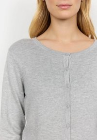 Cardigan grigio a maglia con scollo rotondo e sei bottoni in coordinato sul davanti, tessuto testurizzato con una finitura morbida.