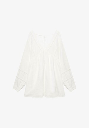 Weiße Bluse mit langen Ärmeln, tiefem V-Ausschnitt, lockerem Schnitt, elastischen Bündchen, Spitzenbesatz und dünner Bindung am Rückenausschnitt.